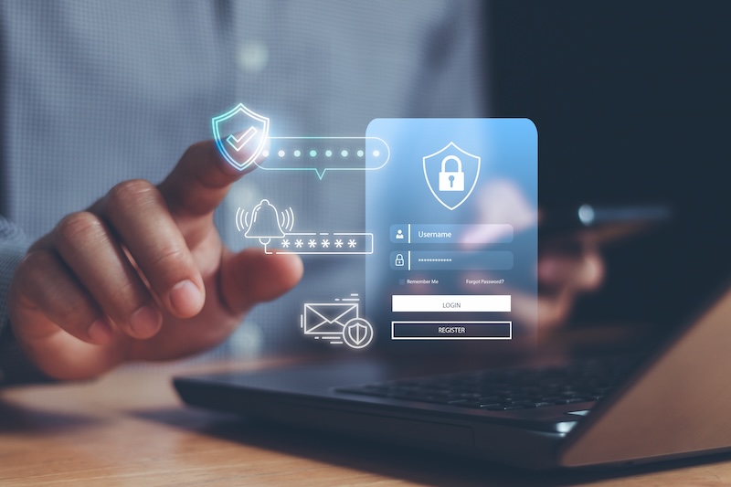 A person uses a laptop with one hand while the other hand interacts with floating digital icons—like a lock, shield, and login form—representing online cybersecurity, data protection, and efforts to block TruthFinder for enhanced privacy.