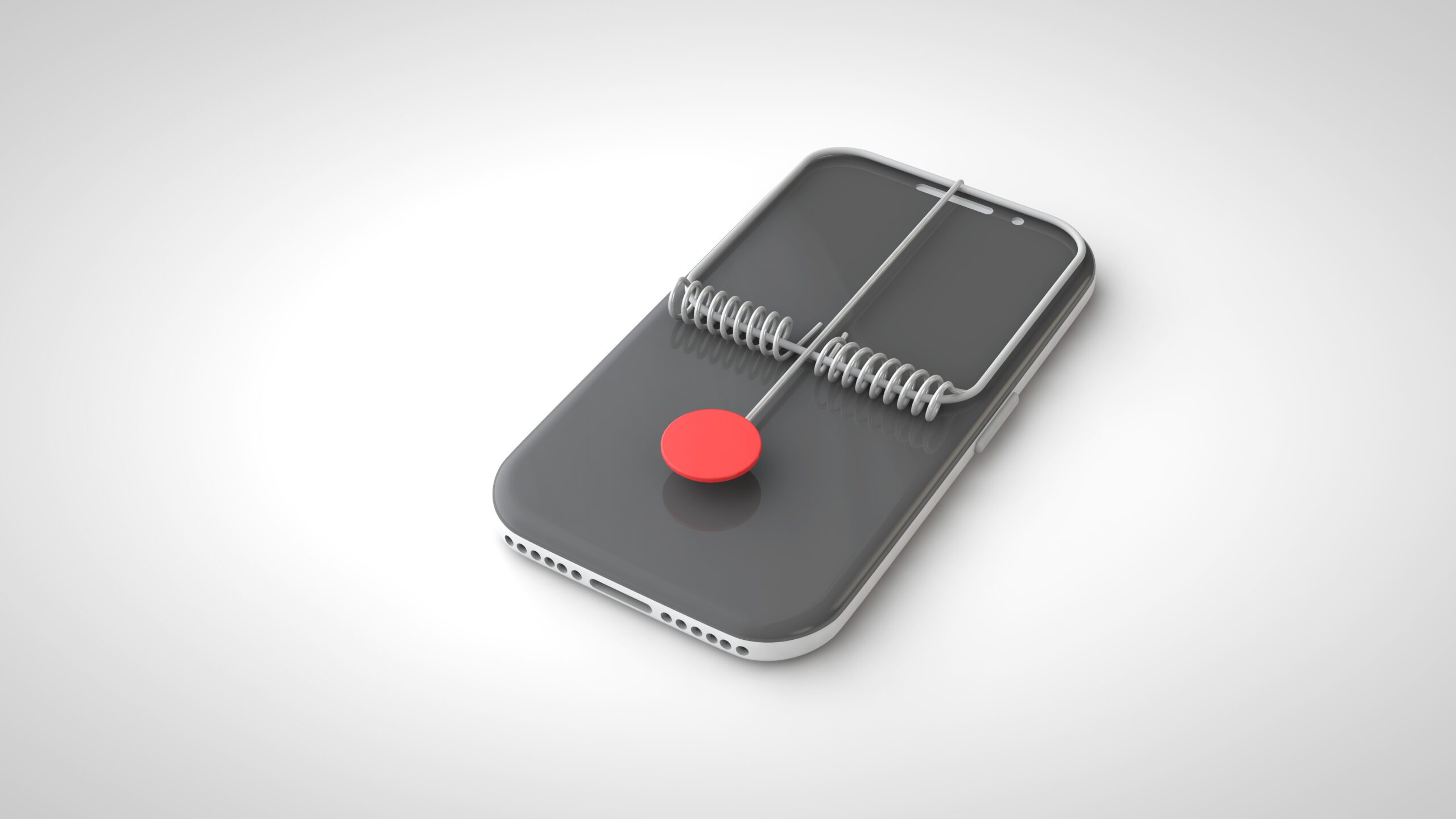 A smartphone with a gray screen is set in a mousetrap style, featuring a metal spring mechanism and a large red button where bait would usually be placed. The background is light gray, creating a minimalist look.