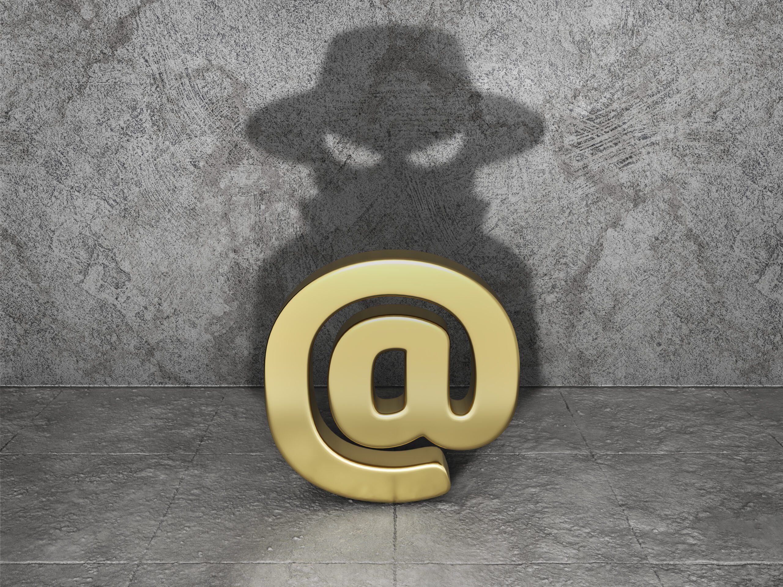 A golden "@" symbol casts a shadow resembling a mysterious figure wearing a hat on a textured stone wall background. The floor is made of stone tiles, contributing to the overall enigmatic atmosphere.